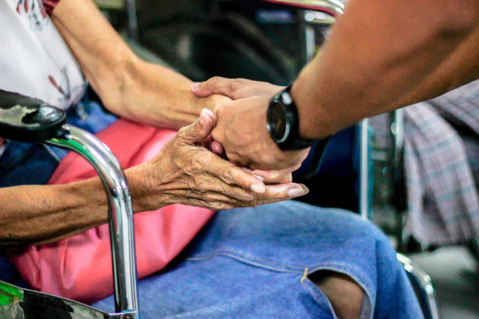 Carer holding the hands of an elderly person