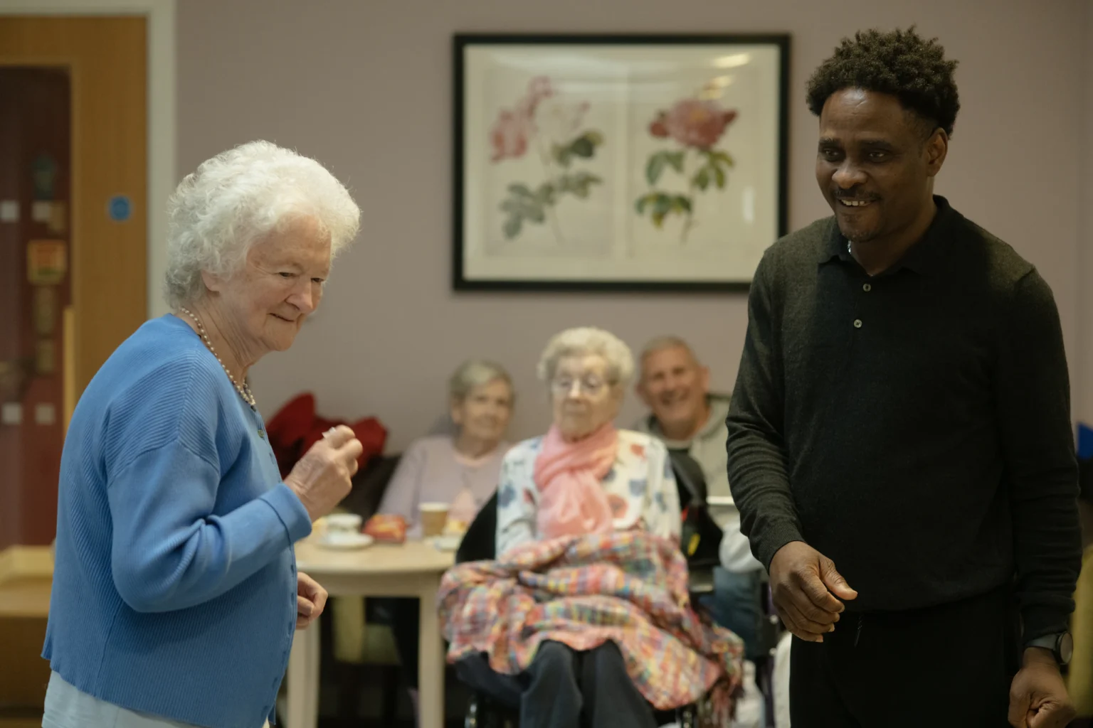 Care worker with residents in a care home lounge