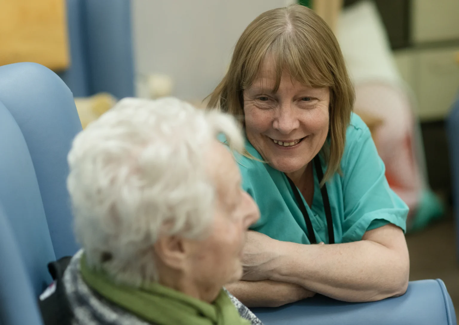 Carer chatting warmly with an elderly woman
